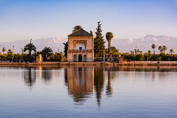 Menara gardens and Atlas in Marrakech, Morocco, Africa at sunset. Water reflection.